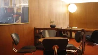 Sudut kedai kopi di Menteng Sudut kedai kopi dengan meja bundar, kursi hitam, dan lampu bulat di Jakarta