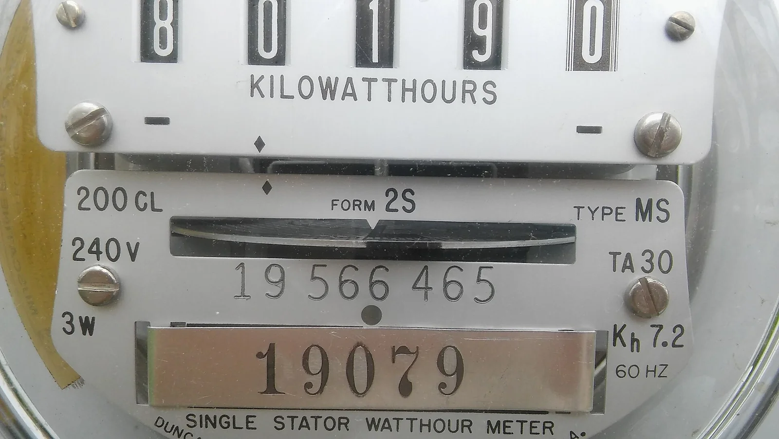 Tampilan dekat meteran listrik analog dengan angka kilowatt jam untuk menghitung biaya listrik AC per bulan
