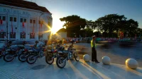 Polisi lalu lintas berjaga di dekat deretan motor patroli saat matahari terbenam