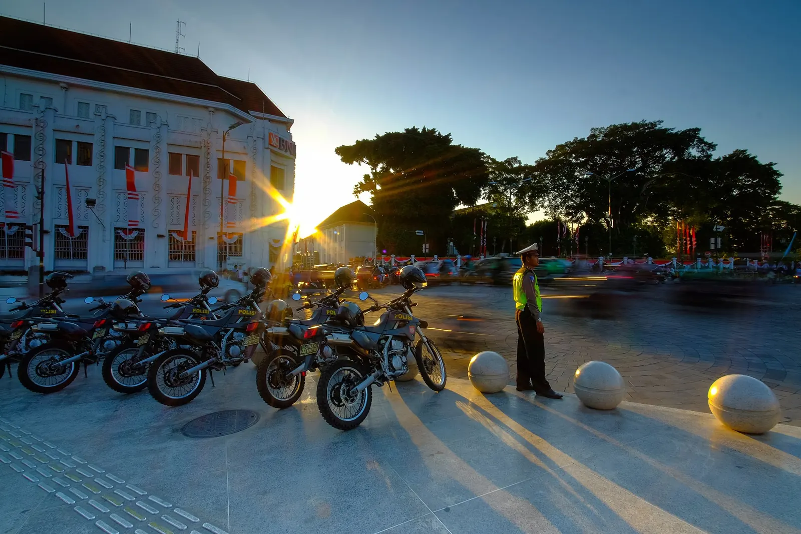 Polisi lalu lintas berjaga di dekat deretan motor patroli saat matahari terbenam