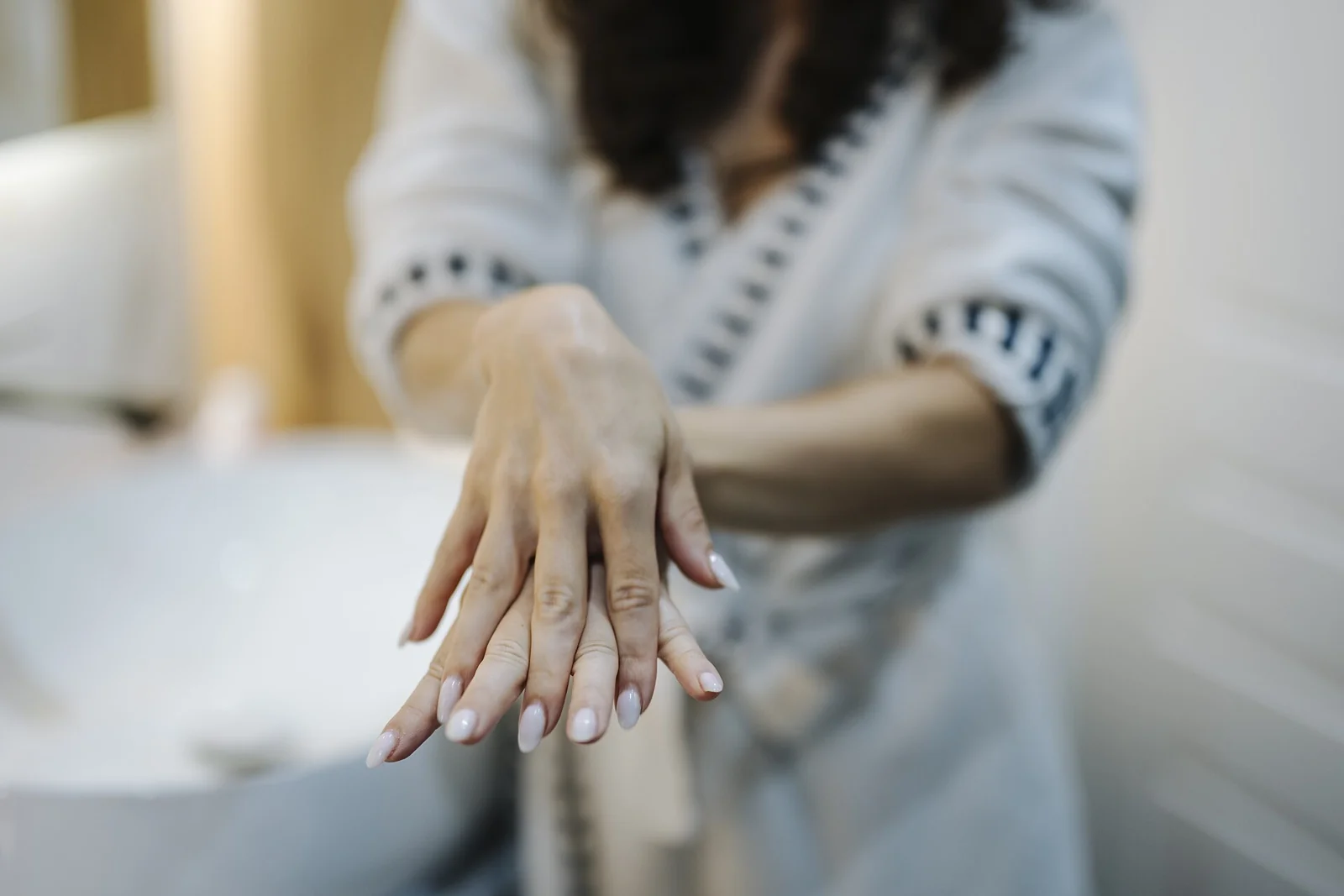 Perempuan menunjukkan kedua tangannya di kamar mandi