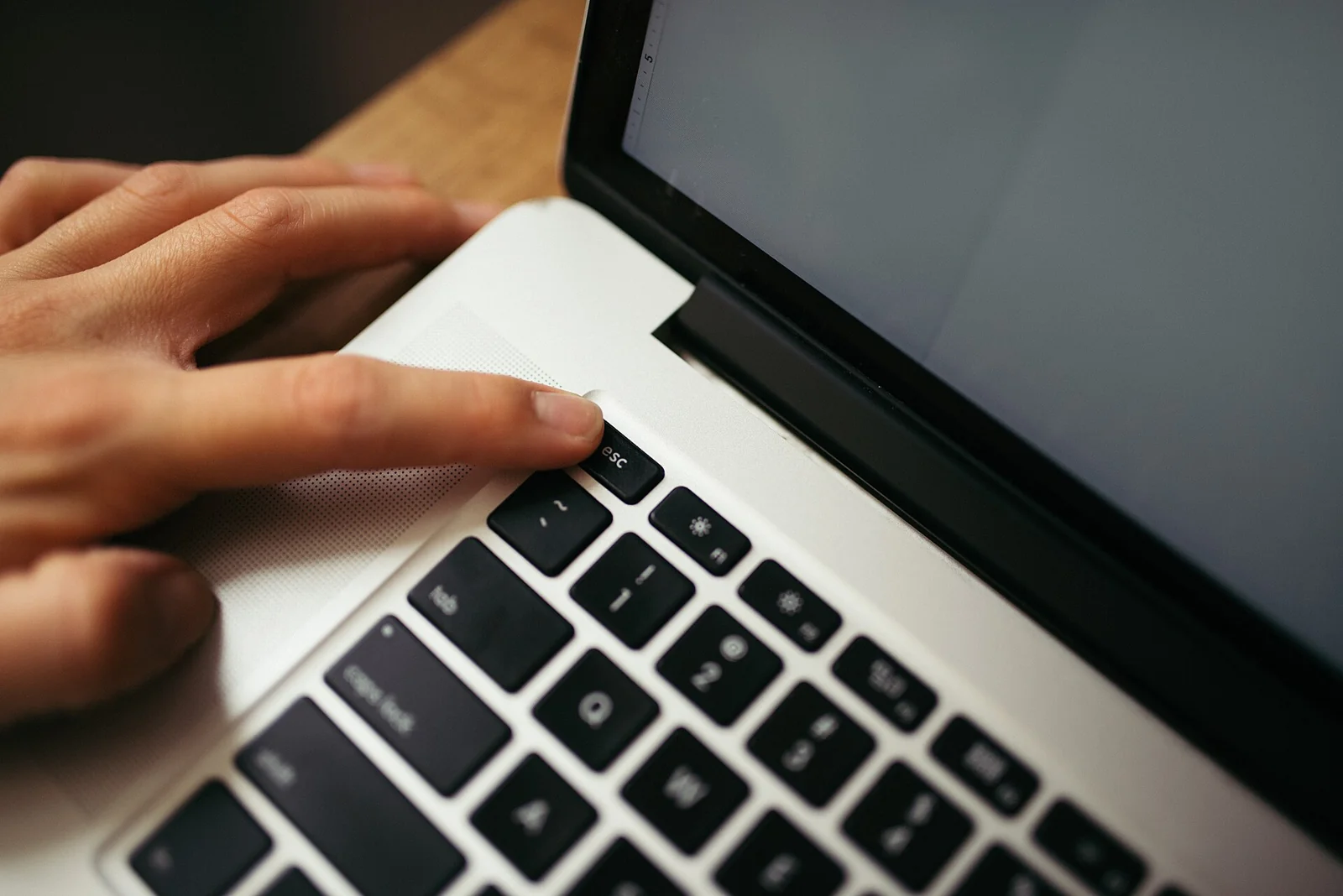 Tangan menekan tombol pada keyboard laptop dilihat dari atas