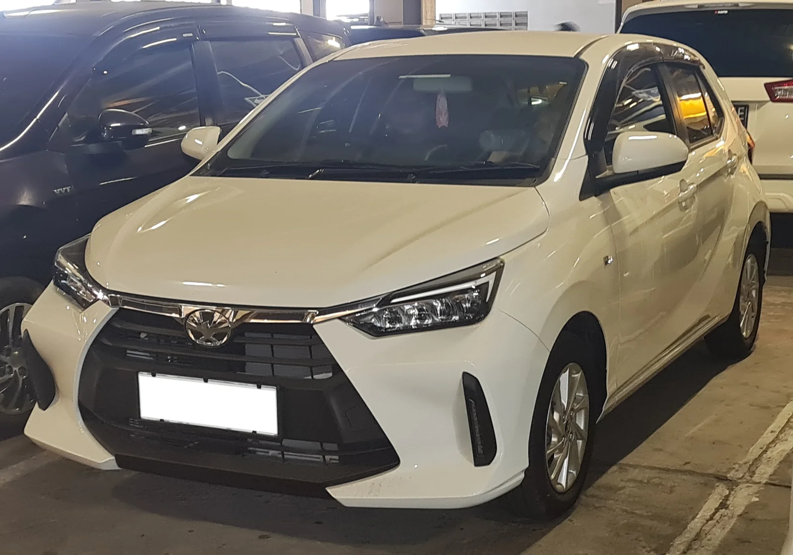 Toyota Agya 1.2 G warna putih terparkir di depan mal