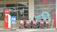 Deretan skuter listrik merah terparkir di lokasi motor sewa depan pusat perbelanjaan