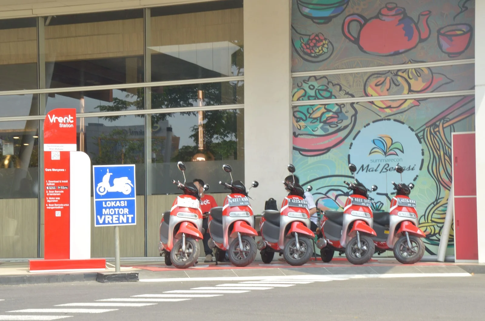 Deretan skuter listrik merah terparkir di lokasi motor sewa depan pusat perbelanjaan