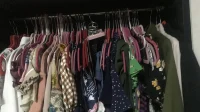 Deretan baju bermotif tergantung rapat di dalam lemari pakaian
