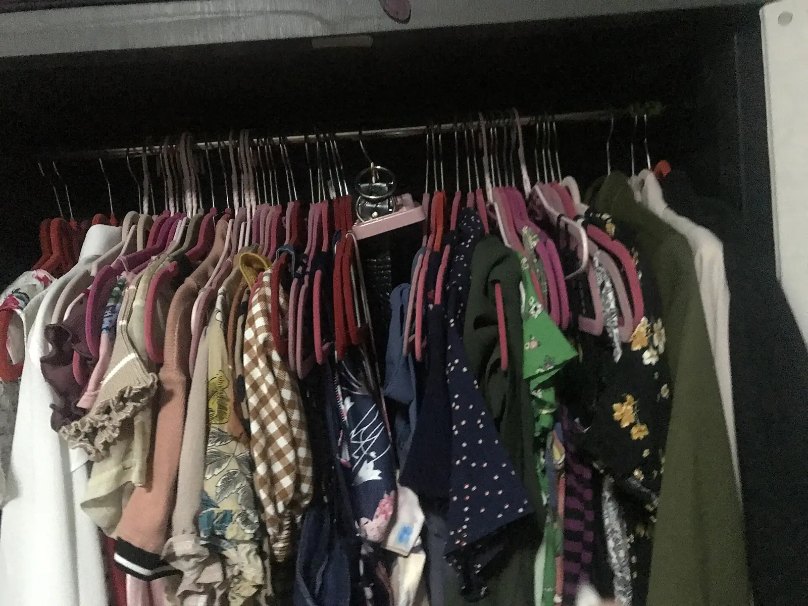 Deretan baju bermotif tergantung rapat di dalam lemari pakaian