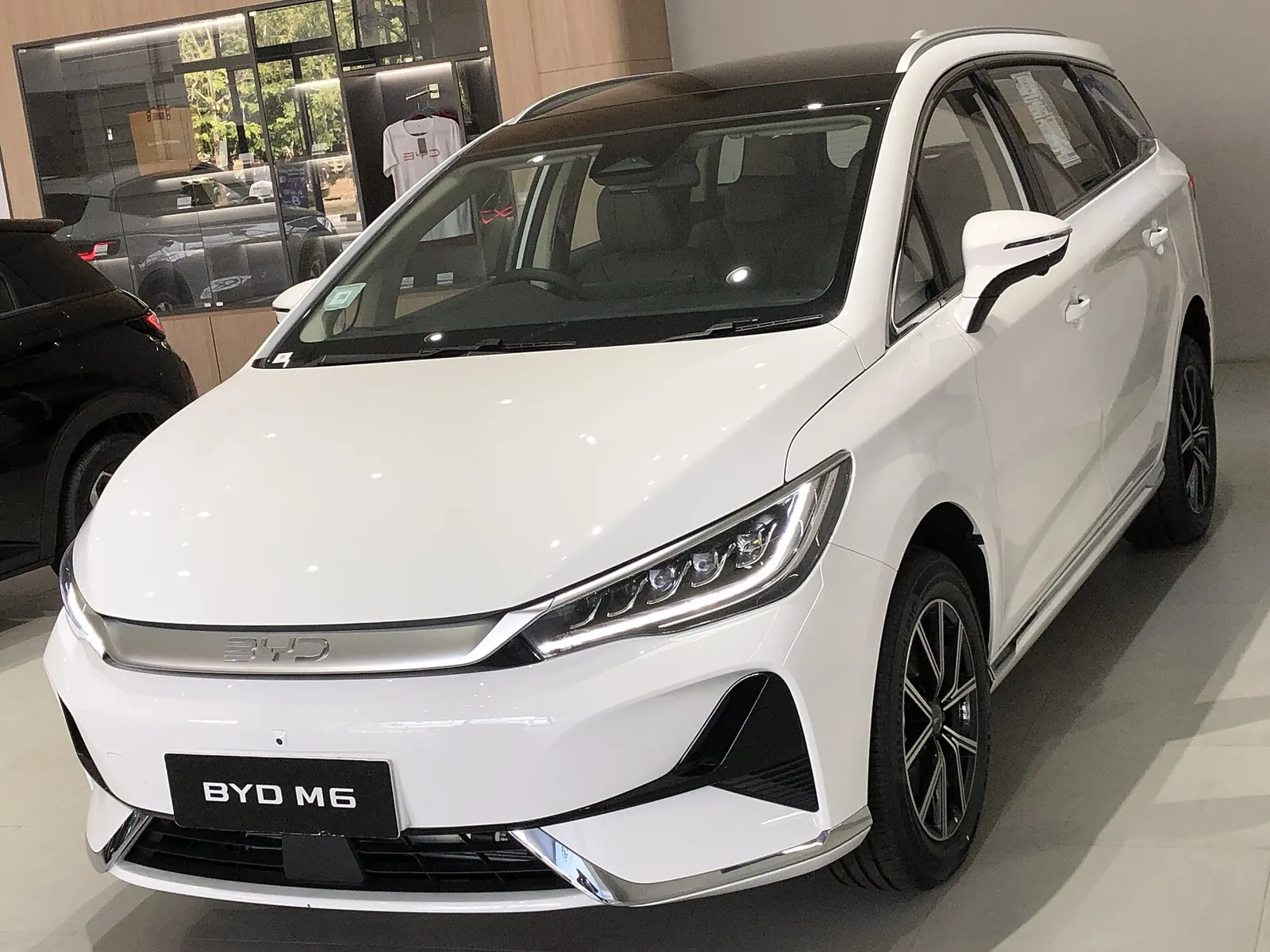 BYD M6 warna putih tujuh kursi di ruang pamer dilihat dari depan