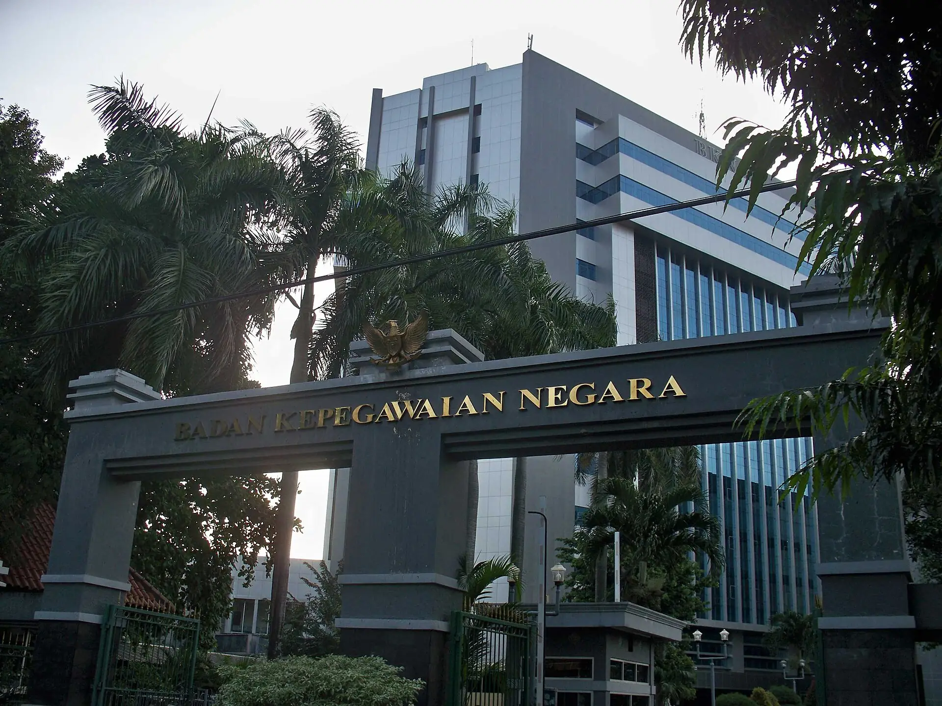 Gerbang bertuliskan Badan Kepegawaian Negara dengan menara Gedung BKN di belakangnya