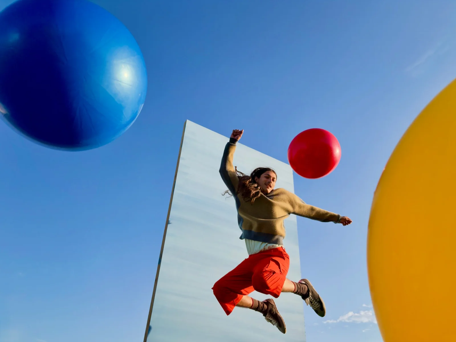 Contoh foto kamera utama 48 MP iPhone Duo, orang melompat dengan balon warna-warni