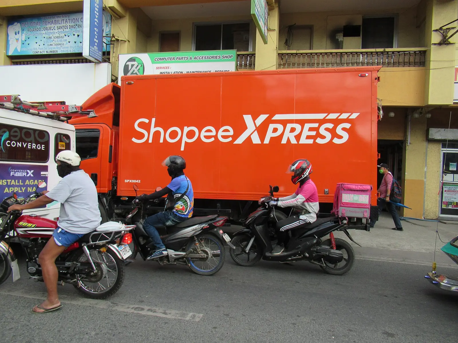 Kurir paket belanja online memeriksa ponsel, gambaran transaksi yang terkena pajak jualan online