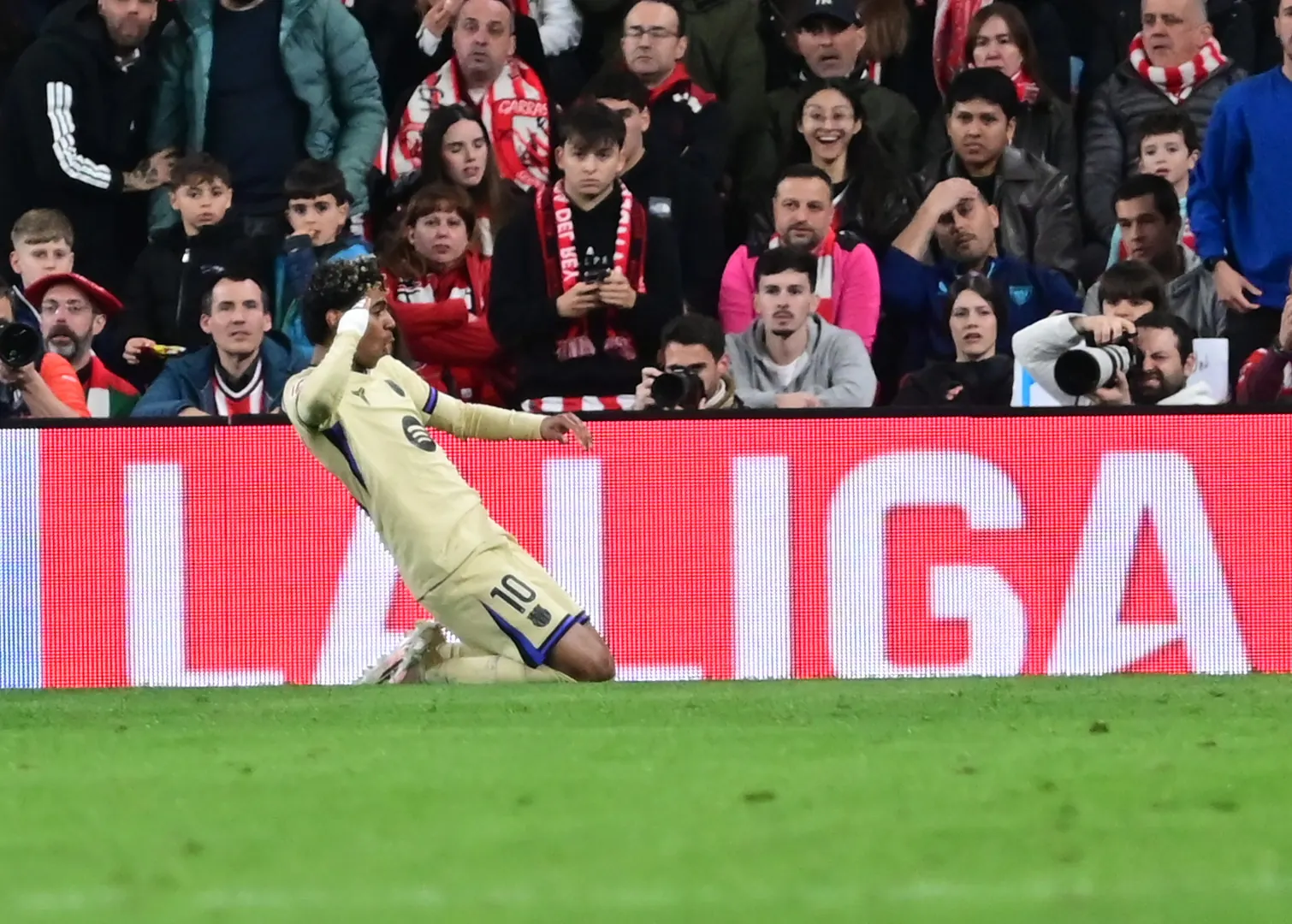 Lamine Yamal berlutut merayakan gol di depan papan LaLiga