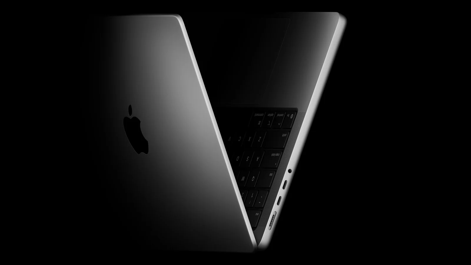 MacBook Pro 14 inci M5 warna space black setengah terbuka di latar gelap