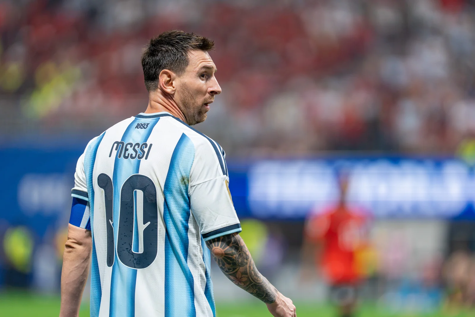 Lionel Messi dengan ban kapten dan jersey nomor 10 Timnas Argentina menoleh ke arah lapangan