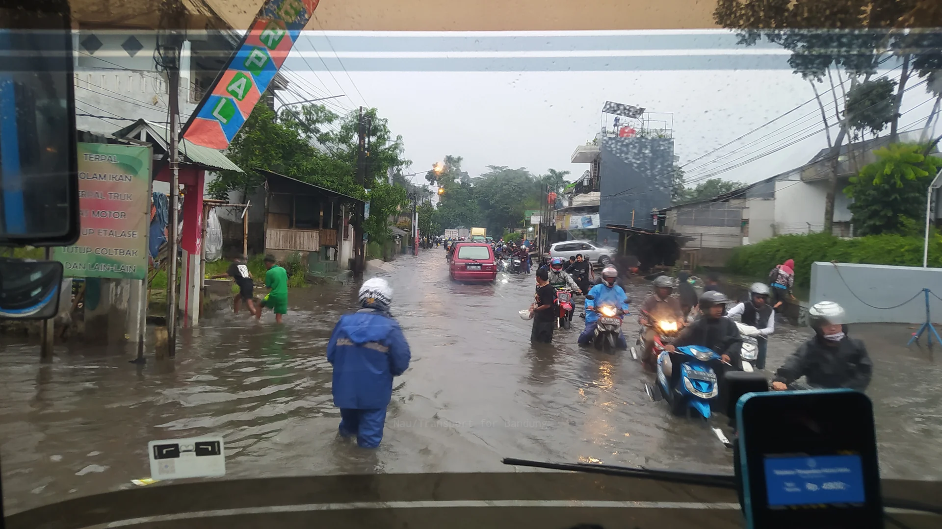 Pengendara sepeda motor menerobos jalan yang tergenang banjir di Dayeuhkolot, Kabupaten Bandung