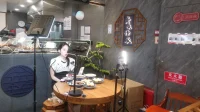 penjual-live-streaming-hp-tripod-lampu Cara jualan live: penjual siaran langsung memperkenalkan produk makanan di depan HP bertripod dan lampu LED