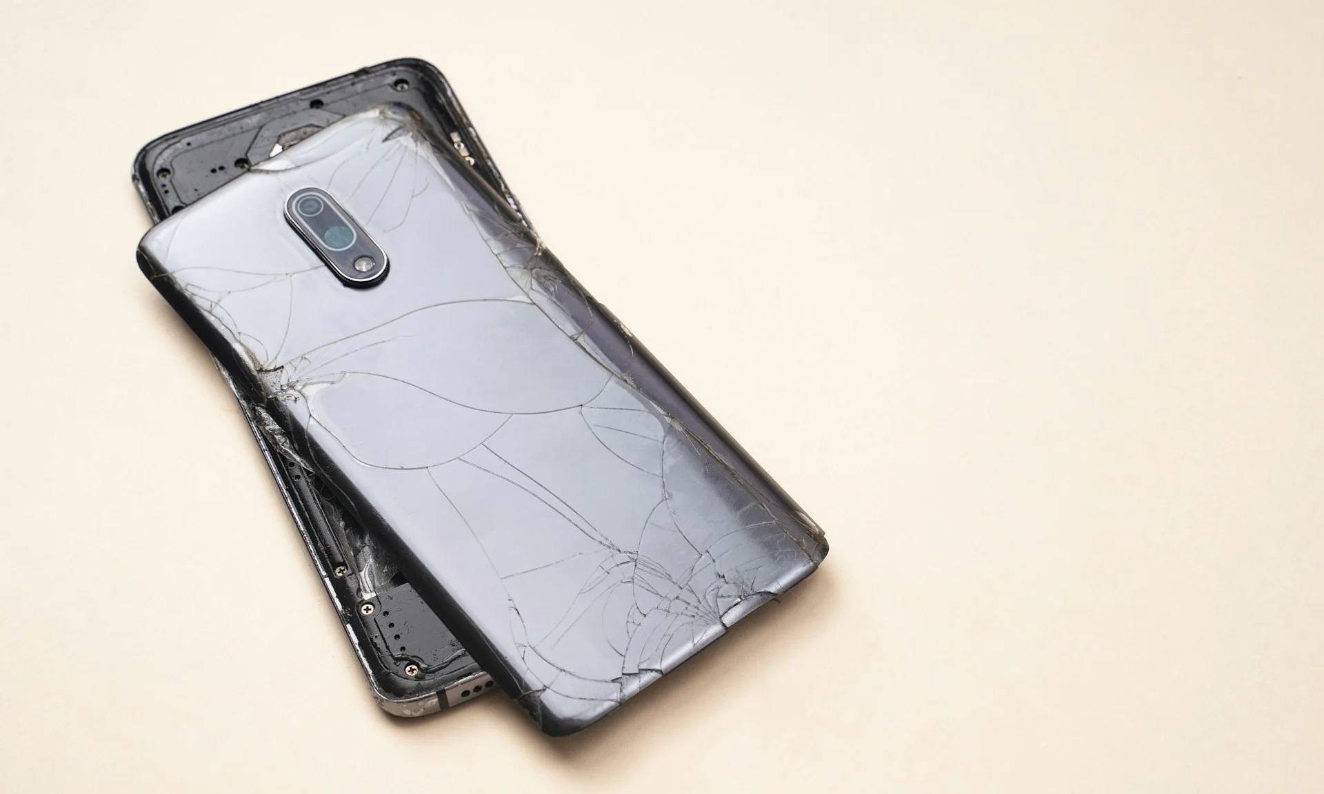 Ponsel lama dengan casing belakang retak terlepas dari rangkanya