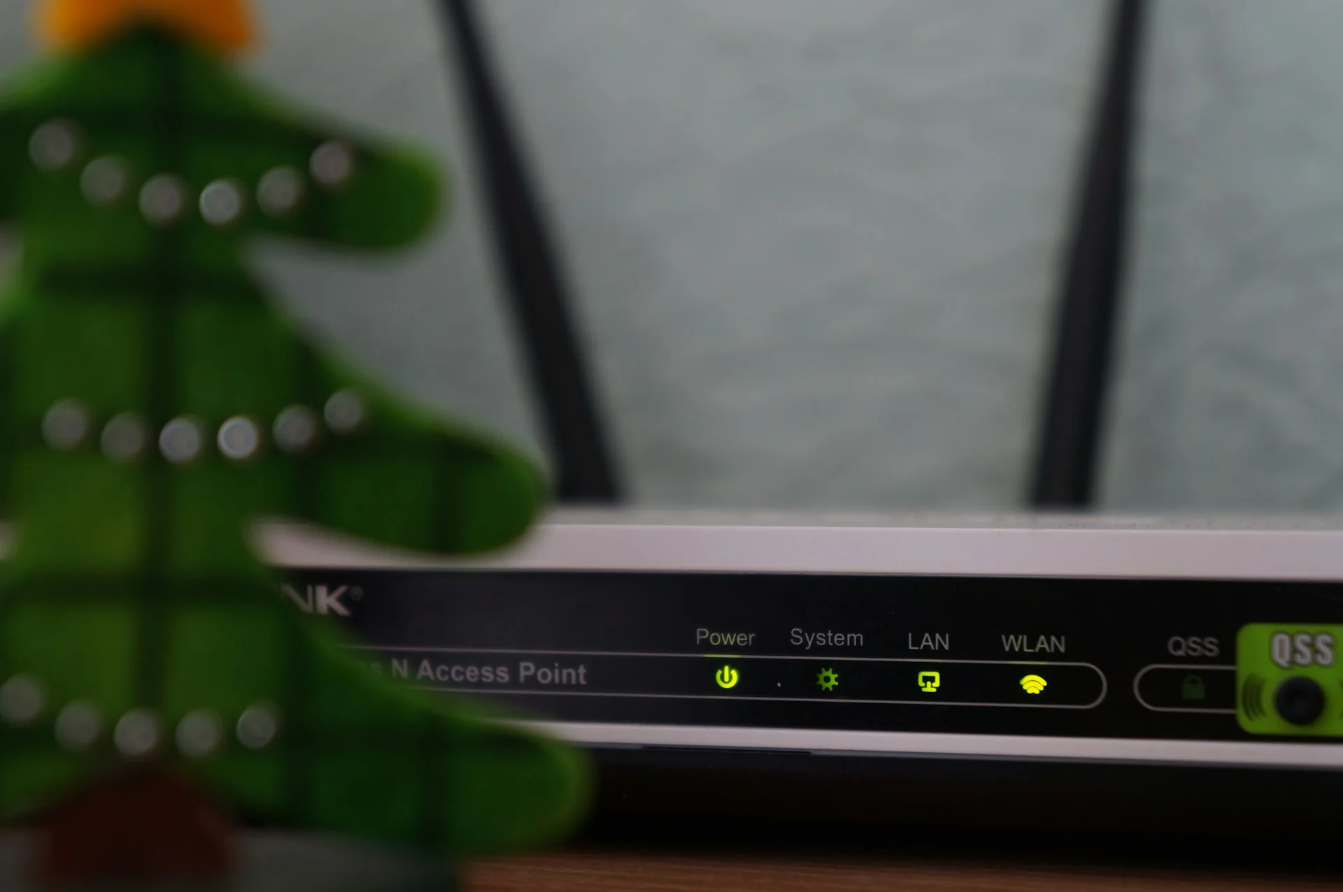 Router Wi-Fi berantena dua dengan lampu indikator Power, System, LAN, dan WLAN menyala