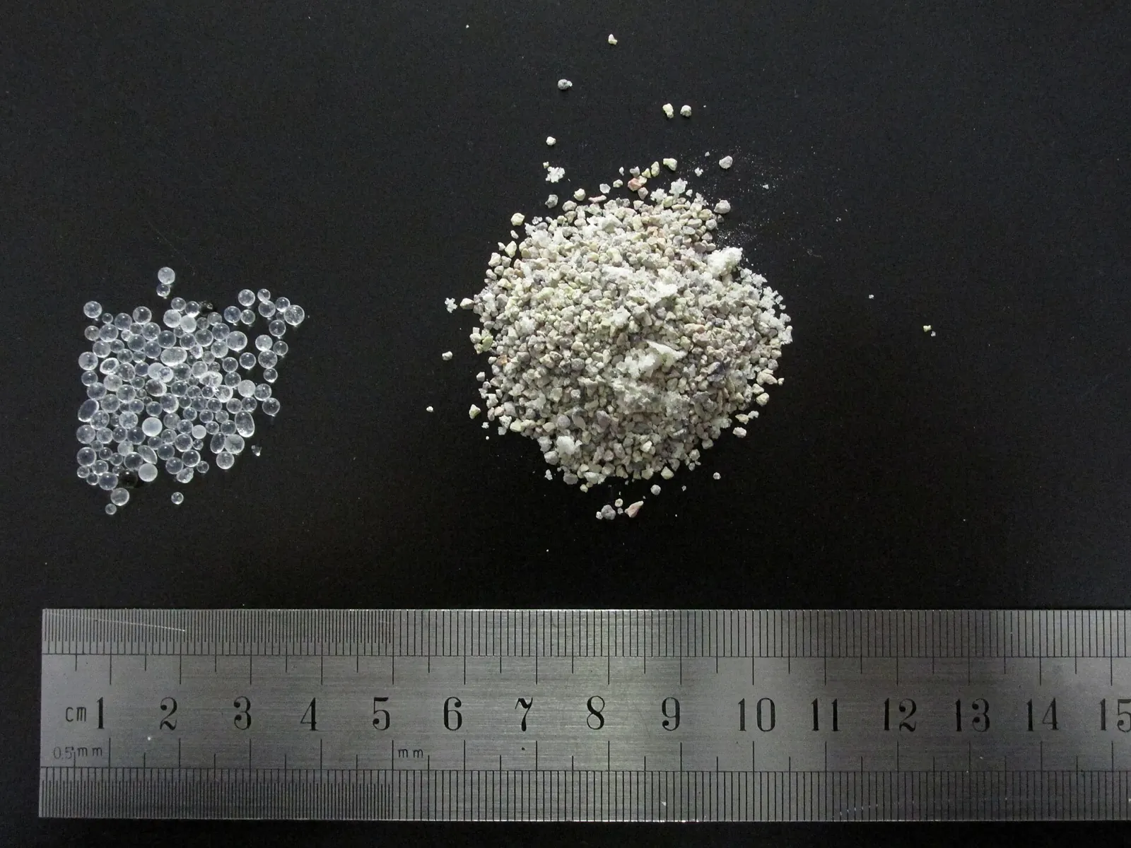 Butiran silica gel bening dan penyerap lembap berbahan tanah liat di samping penggaris
