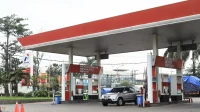 Mobil mengisi BBM di SPBU Pertamina dengan papan Pertamax Turbo, Pertamax, dan Pertalite, gambaran harga BBM Oktober 2026