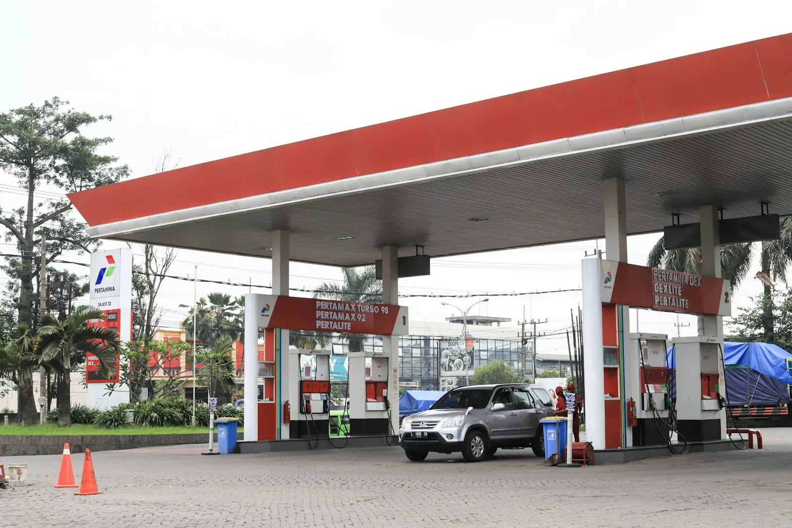 Mobil mengisi BBM di SPBU Pertamina dengan papan Pertamax Turbo, Pertamax, dan Pertalite, gambaran harga BBM Oktober 2026