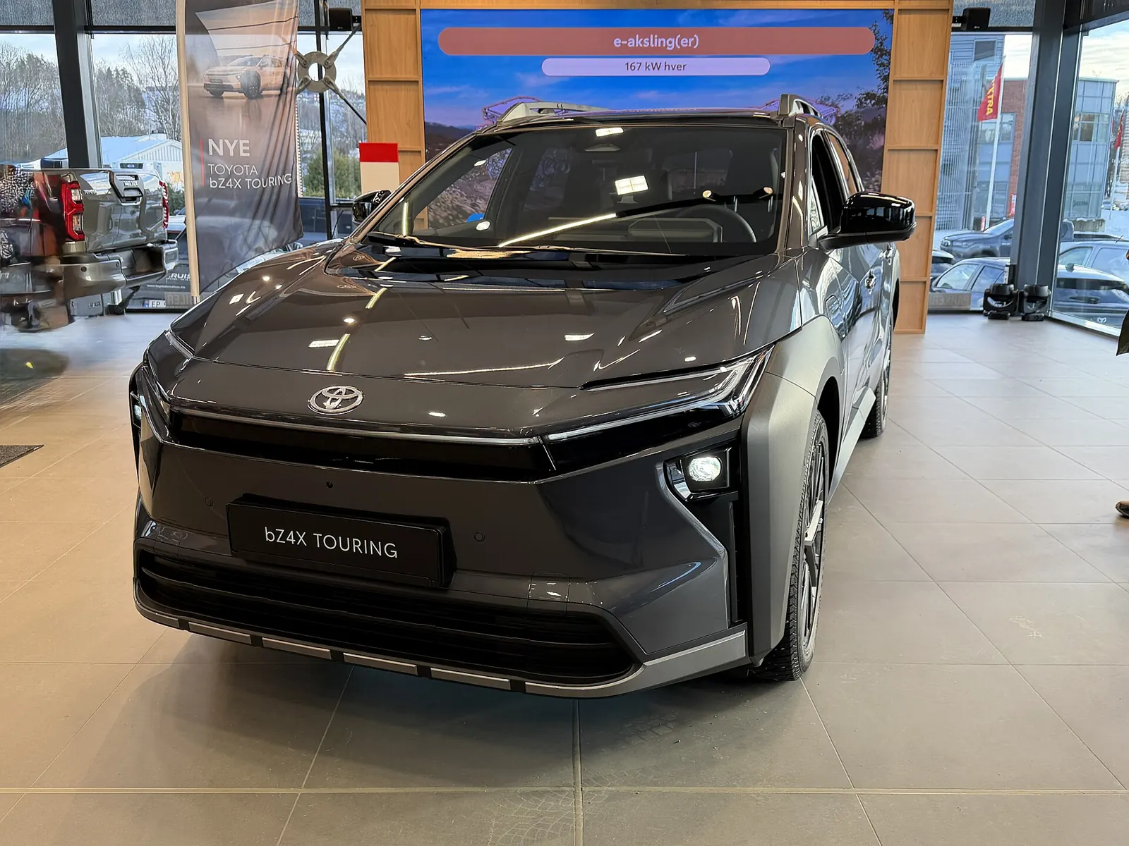 Toyota bZ4X Touring warna abu-abu di ruang pamer diler dilihat dari depan