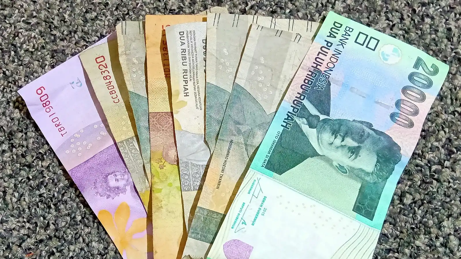 Uang kertas rupiah berjajar, ilustrasi simpanan deposito vs emas