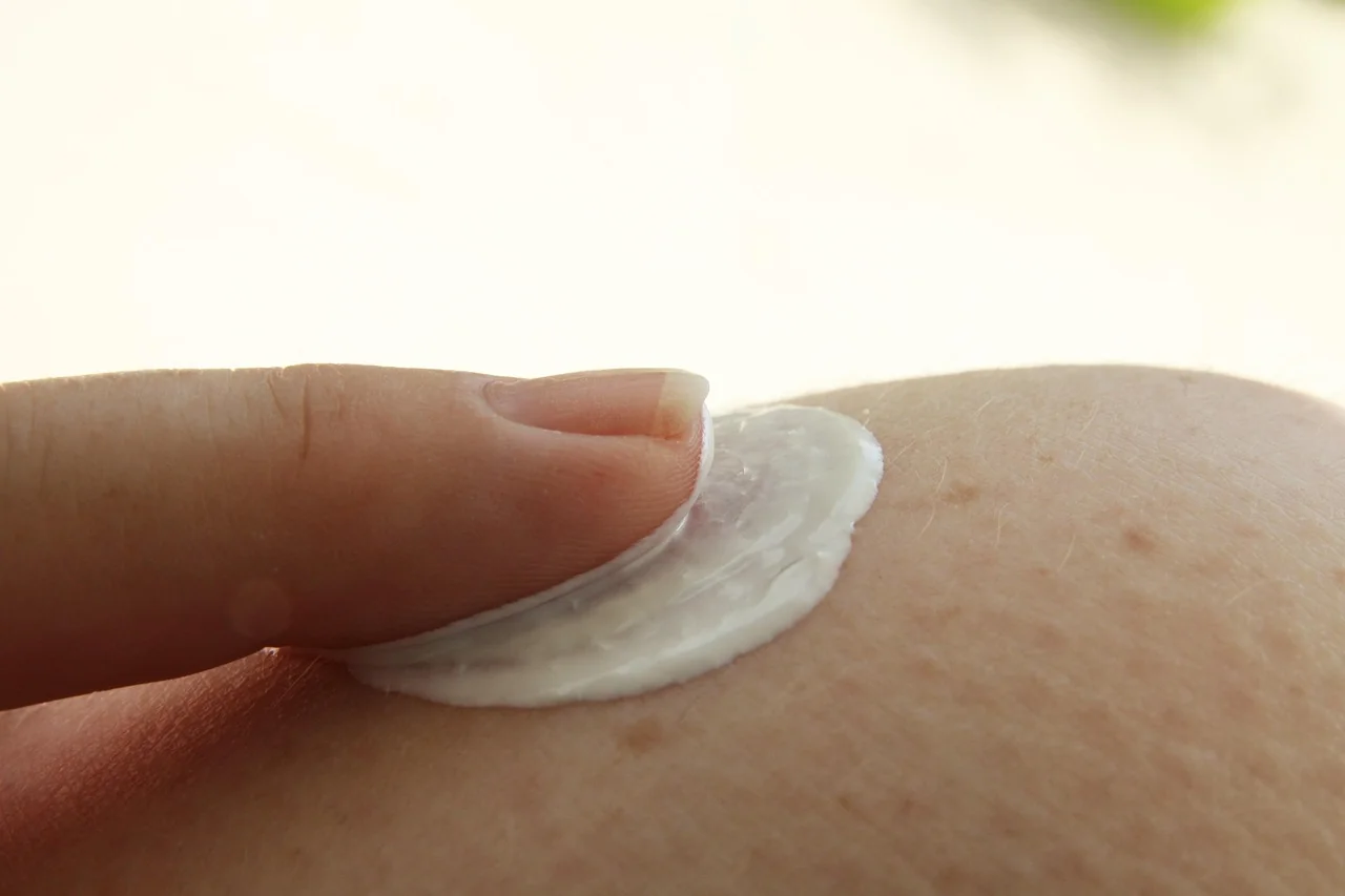 Ujung jari meratakan krim tipis di kulit, ilustrasi cara oles retinol untuk pemula